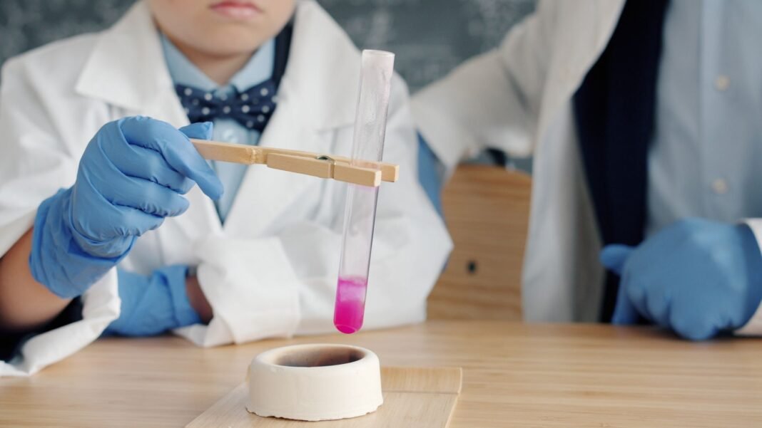 Pennsylvania eighth-grader’s antacid invention earns national science finalist spot Child performs chemistry experiment with pink solution in test tube.