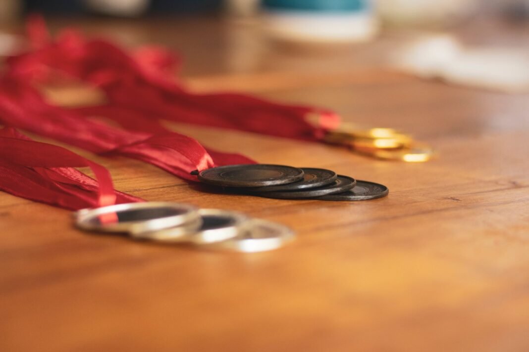 Suchika Tariyal wins bronze at Asian Games, but 700-gram rule denies her a shot at MMA gold Close-up of gold, silver, and bronze medals with red ribbons on a wooden table.