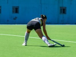 A dynamic moment captured of a female field hockey player in action during a match on a sunny day.