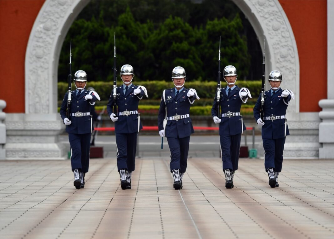 Trump-Xi summit: $14 billion Taiwan arms deal hangs over Washington talks Five uniformed military personnel marching in formation during a ceremonial parade outdoors.
