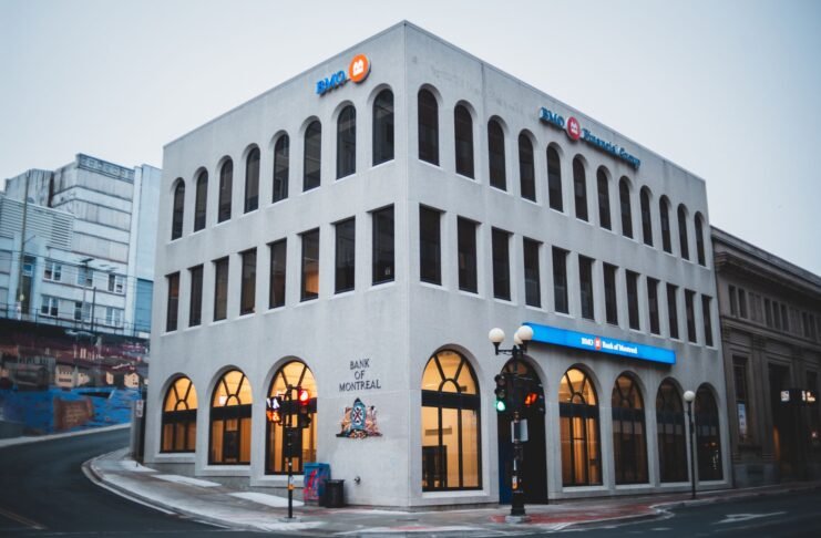 Exterior of contemporary building of bank with arched passages near asphalt road in evening