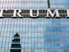 Close-up of Trump Tower's glass facade with the city skyline reflection in the windows.