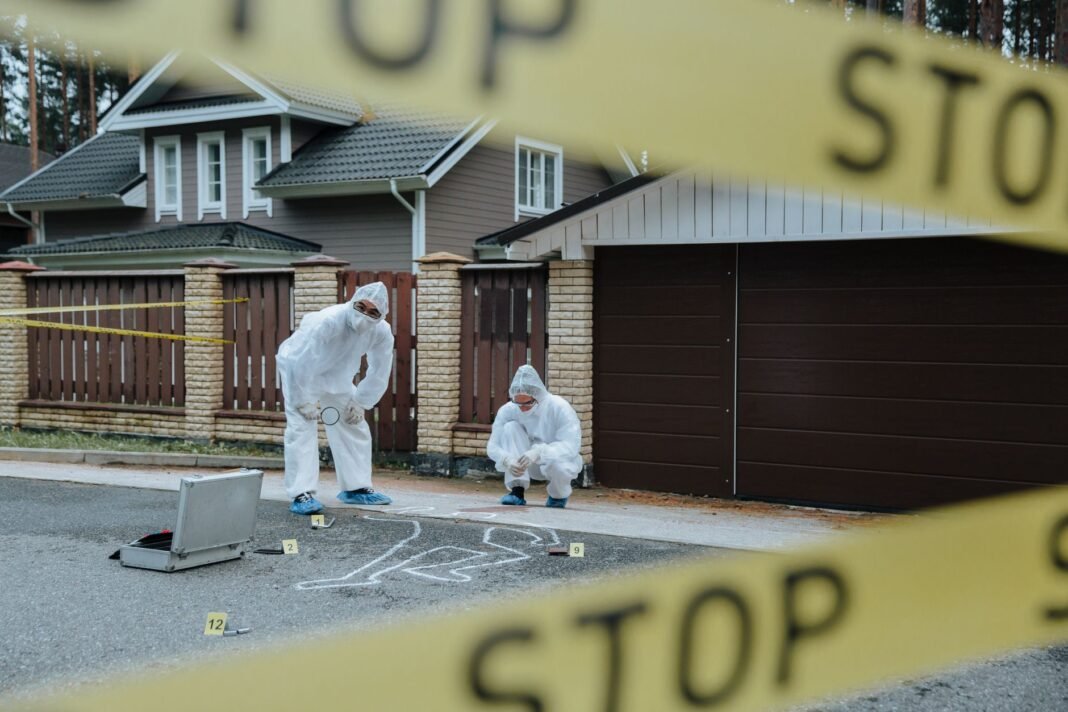 Karnataka man murdered in UAE, body cut into 9 pieces; wife, son untraceable Forensic team examining crime scene with chalk outline and evidence markers outdoors.